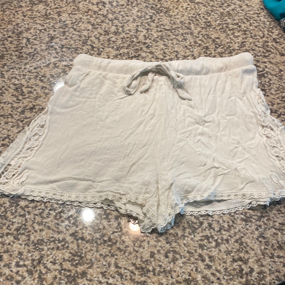 Cream shorts with elastic and draw string waste. Lace design on sides.
